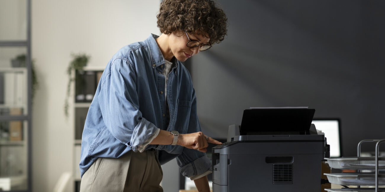 side view woman using printer
